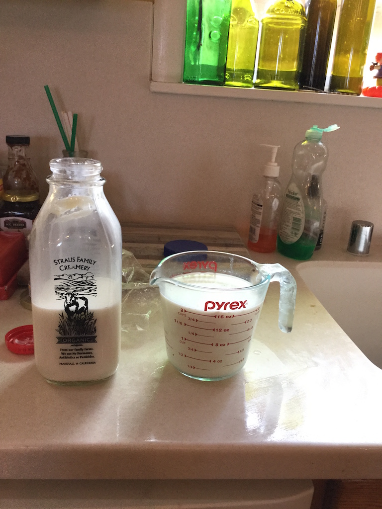 Picture of a bottle of open milk and a full 2 cup glass measure of milk